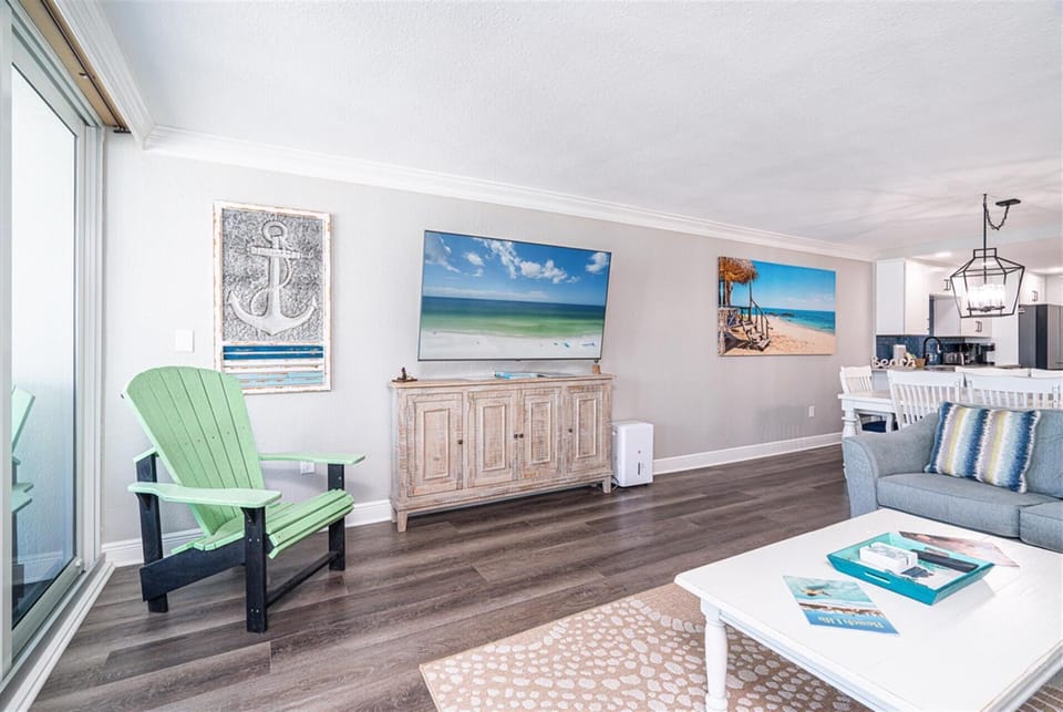 Relax in your coastal-themed living space where ocean artwork and mint green furnishings create the perfect beach house ambiance for your stay.