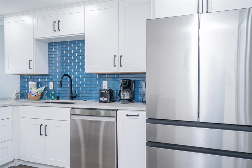 Your fully equipped kitchen features stainless steel appliances and stunning blue tile backsplash, perfect for preparing meals during your stay.