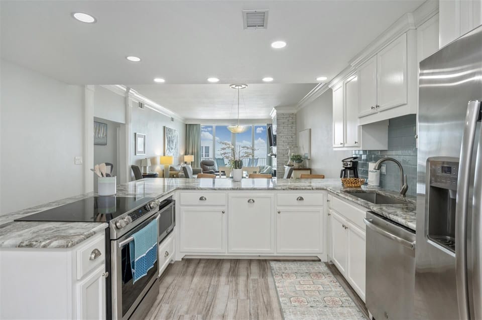 Your dream kitchen awaits with gleaming granite counters, white cabinetry, and stainless steel appliances perfectly positioned for memorable meal prep.