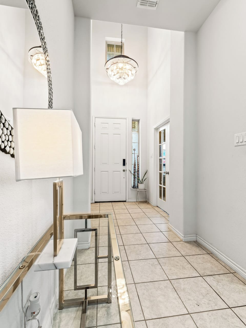 Step into your elegant entryway where a stunning crystal chandelier welcomes you home, setting the tone for your sophisticated retreat.