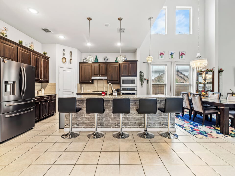 Gather around this stunning kitchen island with sleek bar seating, perfect for morning coffee or evening conversations in your spacious, light-filled culinary haven.