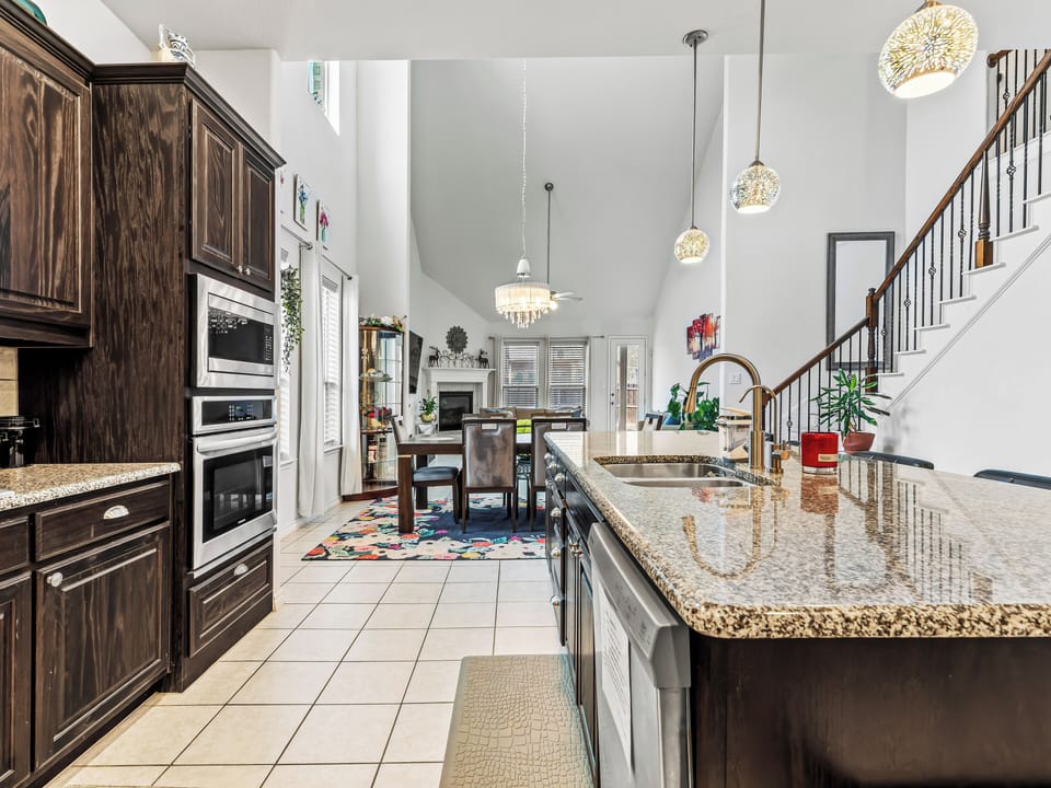 Your gourmet kitchen awaits with gleaming granite countertops, rich wood cabinetry, and an open layout perfect for cooking memorable meals together.