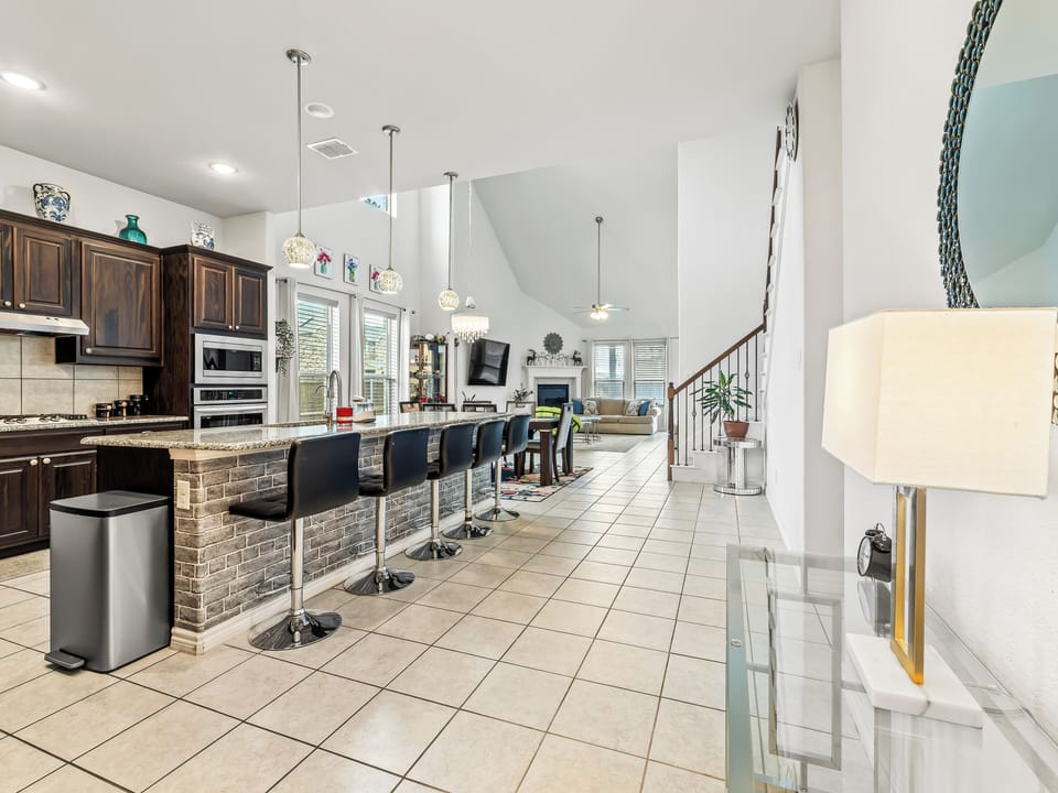 Gather around this spacious kitchen island where granite countertops meet modern bar seating—your perfect spot for morning coffee and evening conversations.