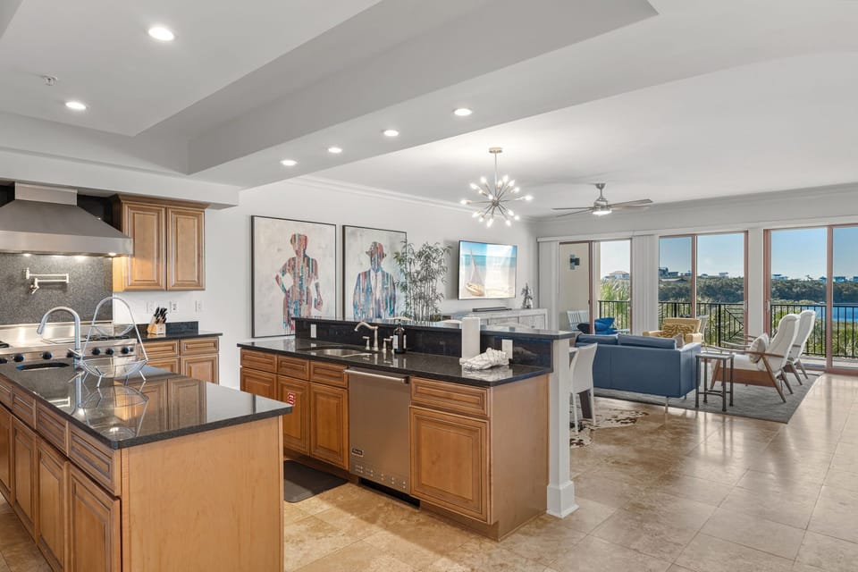 This open kitchen flows seamlessly into the living space, featuring premium appliances and stunning water views through floor-to-ceiling windows.
