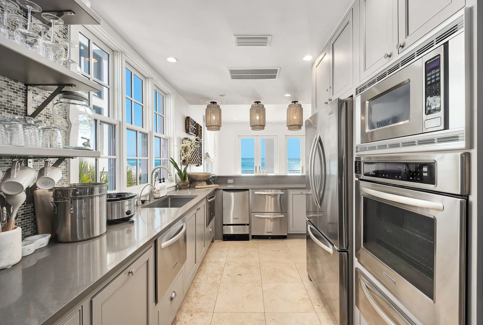 Cook like a chef in this stunning galley kitchen featuring premium stainless steel appliances, gleaming countertops, and ocean views.