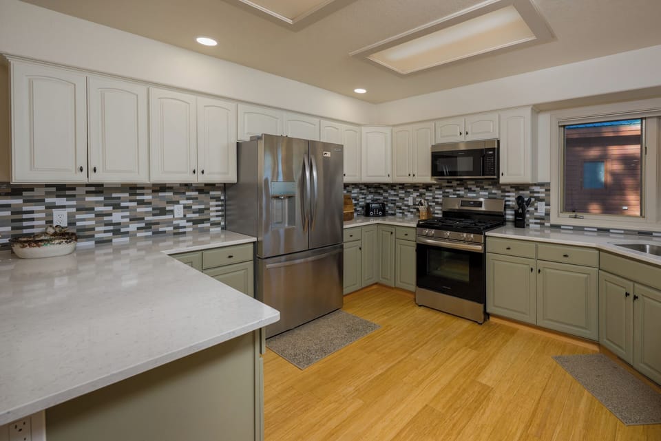 Your gourmet kitchen awaits with stainless steel appliances, spacious countertops, and elegant white cabinetry—perfect for preparing memorable meals during your stay.
