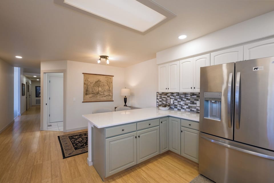 Your stylish kitchen awaits with stainless steel appliances, granite countertops, and a charming skylight flooding the space with natural warmth.