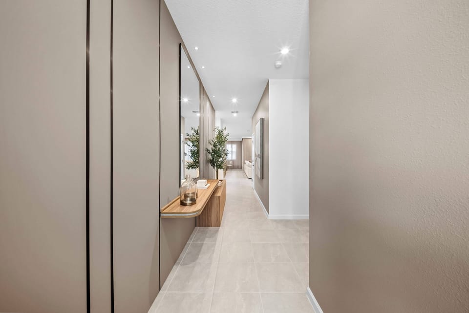 Enter a beautifully designed hallway with light walls and warm wooden accents. The stylish console table and greenery enhance the inviting atmosphere, making you feel truly at home.