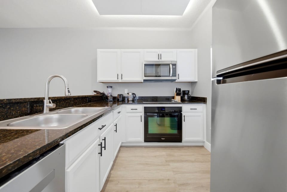 Enjoy a bright kitchen with stylish white cabinetry and rich granite countertops, creating a clean atmosphere. Modern stainless steel appliances make meal preparation easy and enjoyable during your stay.