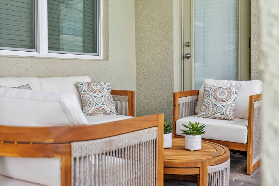 Relax in our inviting outdoor nook with chic wicker seating and plush, patterned cushions. The warm wood accents and natural textures create the perfect atmosphere for you to savor a refreshing drink and enjoy peaceful moments.