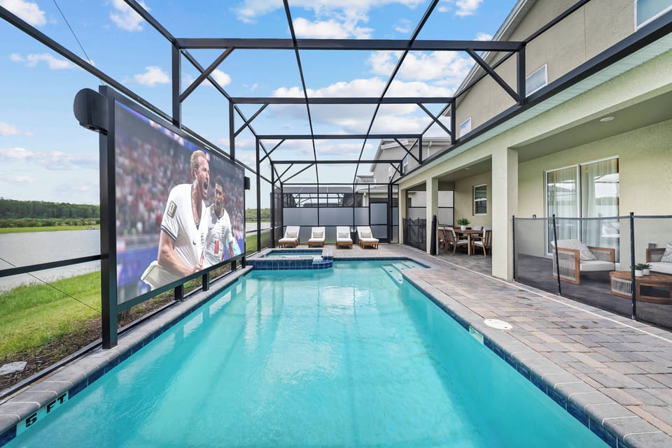 Step outside to enjoy a stunning pool area with comfortable lounge chairs and an outdoor screen ideal for movie nights. The modern design includes a protective enclosure, letting you savor the gentle breeze and beautiful views.