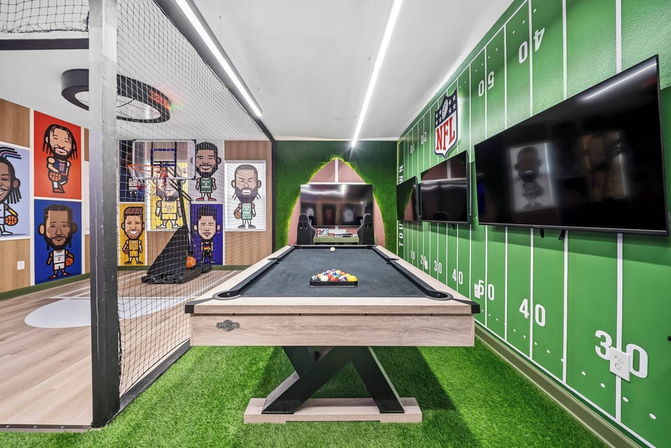 Step into a vibrant game room featuring a sleek pool table, surrounded by colorful sports-themed decor. With artificial grass underfoot and multiple large TVs, this space offers endless entertainment for guests of all ages.