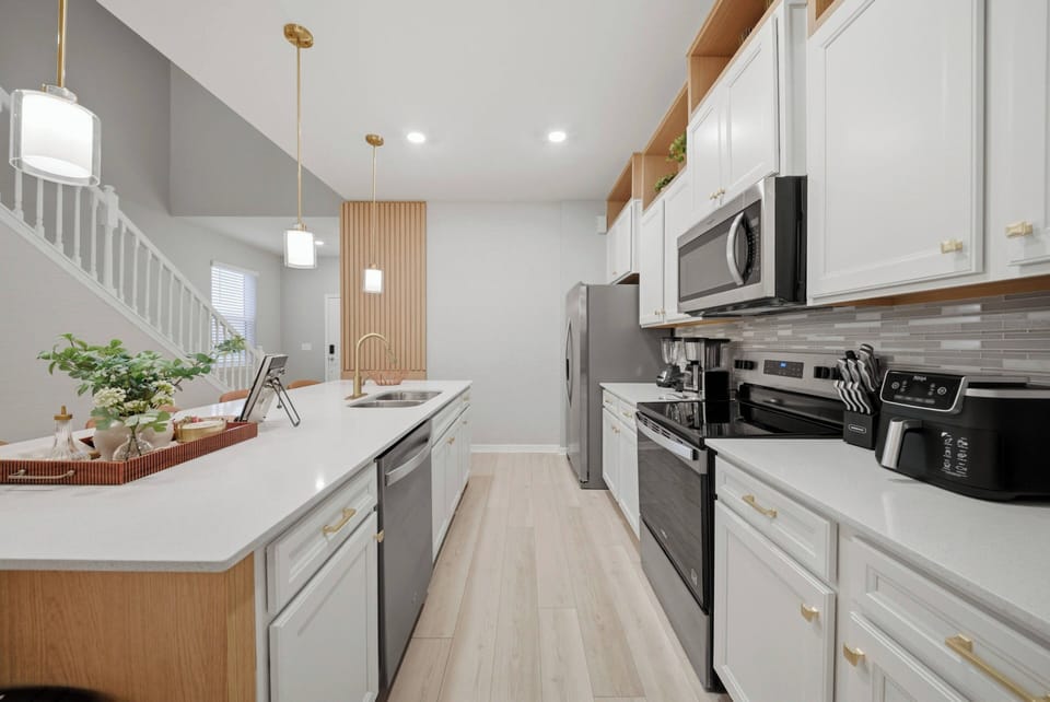 Experience a stunning kitchen featuring chic white cabinets and modern stainless steel appliances, ideal for your cooking adventures.