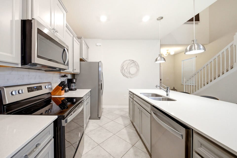 Discover the charm of this designer kitchen with sleek stainless steel appliances and elegant white cabinetry. The spacious countertop inspires culinary creativity, beautifully highlighted by stylish pendant lights for a bright.
