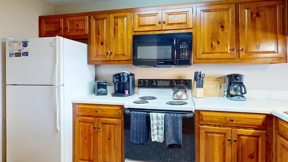 Prepare your favorite meals in this fully-equipped kitchen with warm wood cabinets, appliances, and everything you need for a comfortable stay.