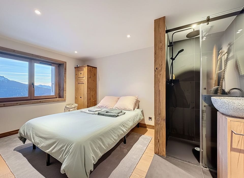 Bright bedroom with en-suite shower room and mountain views, blending comfort and privacy in a peaceful setting.