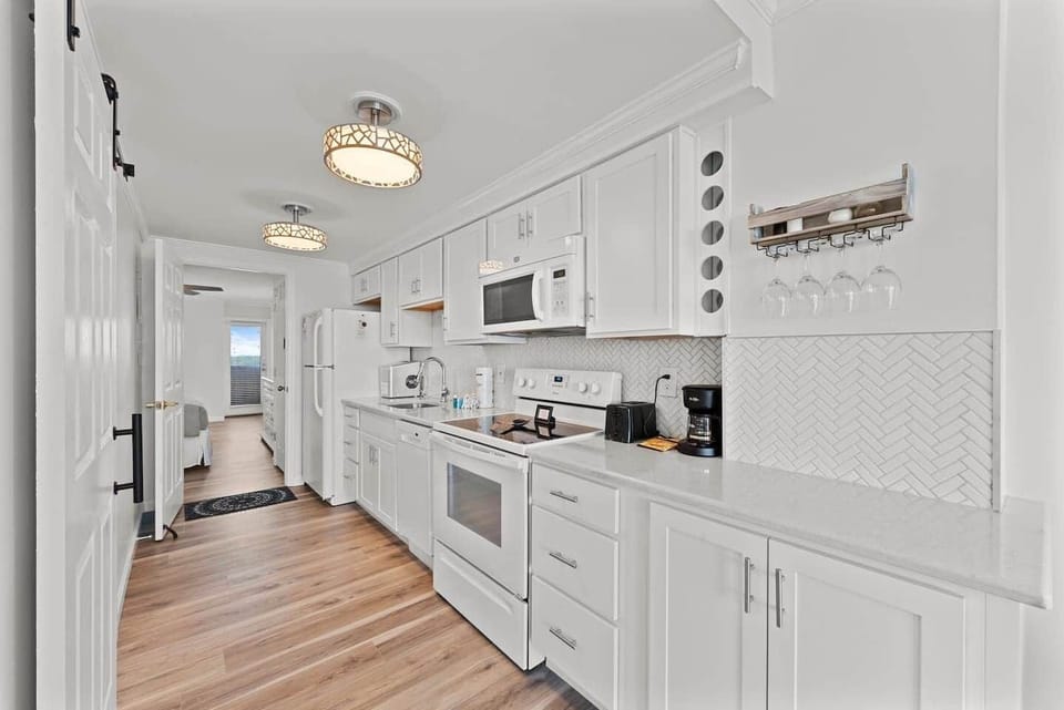 Bright, coastal galley kitchen with crisp white cabinetry, modern appliances, and stylish finishes—perfect for easy beachside meals and entertaining. ️