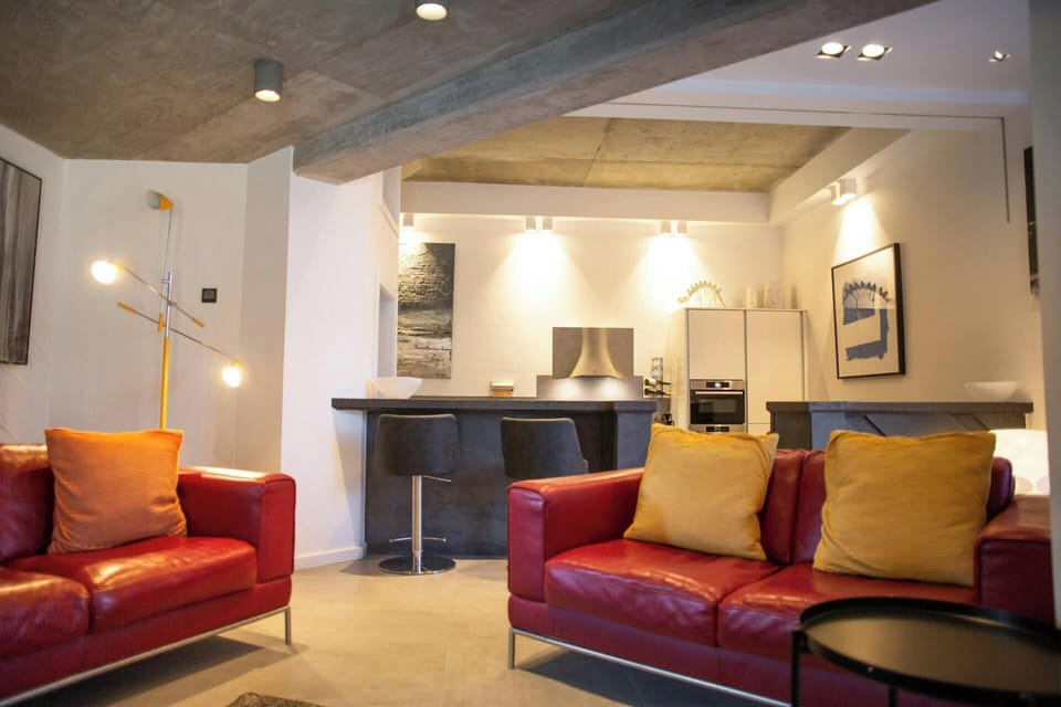 Living area with two sofas, breakfast bar with two stools, kitchen area