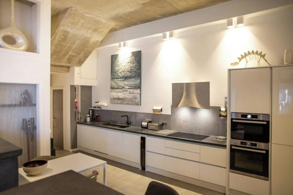 Kitchen with ovens, hob and extractor, sink, table and chairs and breakfast bar