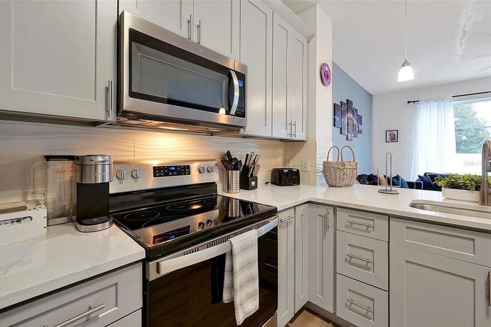Fully equipped kitchen featuring a gas range, built-in microwave, granite countertops, and ample prep space.