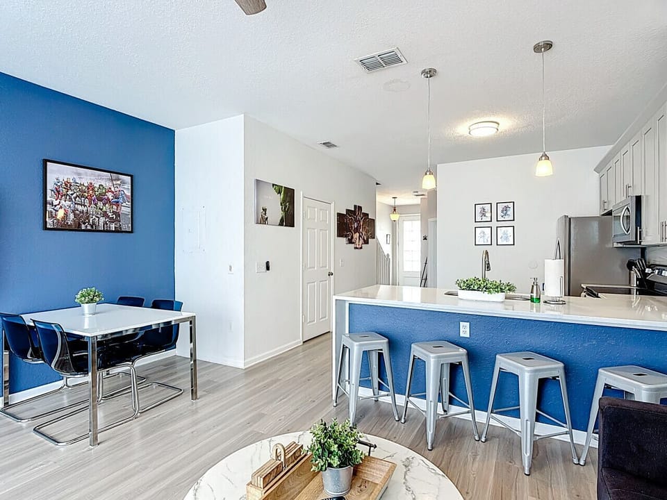 Open-concept dining and kitchen area with breakfast bar and fully equipped appliances.