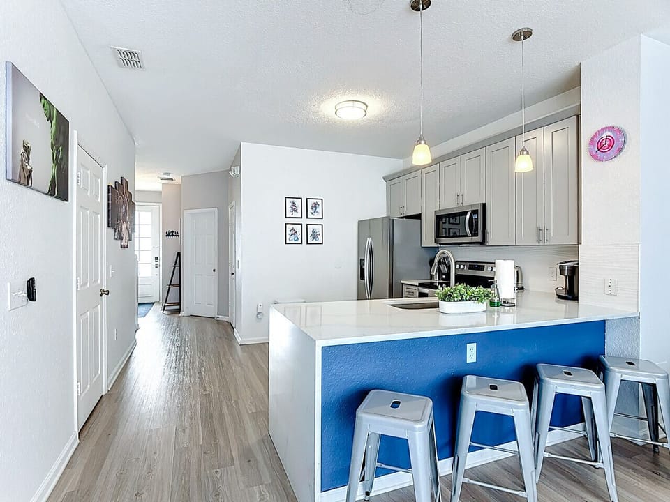 Open-concept kitchen with breakfast bar seating, stylish pendant lighting, and contemporary finishes.