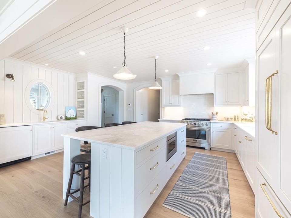 Bright and spacious kitchen featuring elegant white cabinetry, a large island, and modern appliances for family-friendly cooking.
