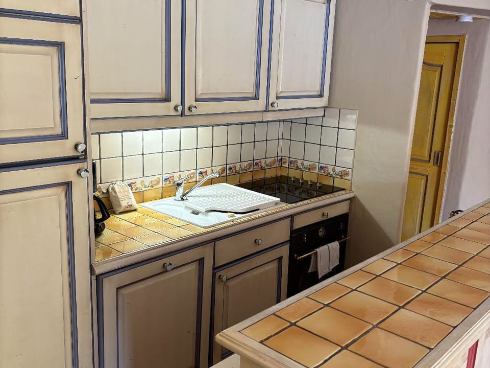 Fully equipped kitchen with ample counter space and traditional tiled finishes.