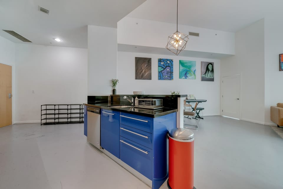 Enjoy this airy living space with sleek mid-century modern furniture and vibrant local art
