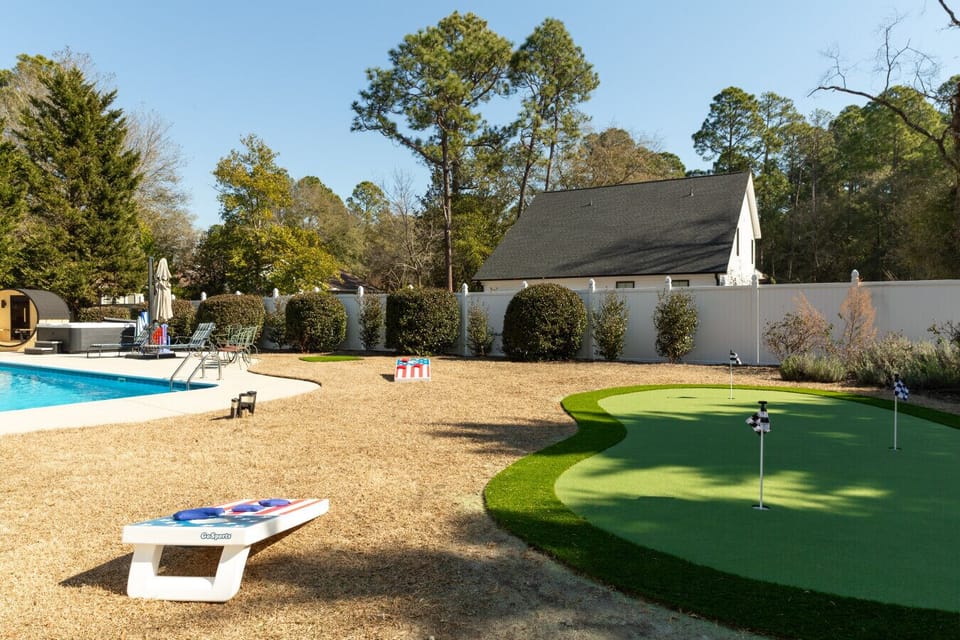 Enjoy the fully fenced backyard featuring a putting green and outdoor games for all ages ⛳