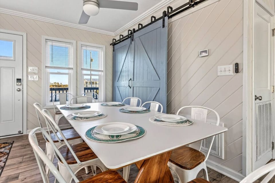This bright dining space opens right onto a waterfront deck with those gorgeous barn doors adding some serious coastal charm.