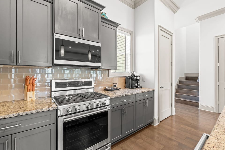 Bright, well-stocked kitchen with ample counter space, bar seating, and easy access to the dining and living areas.