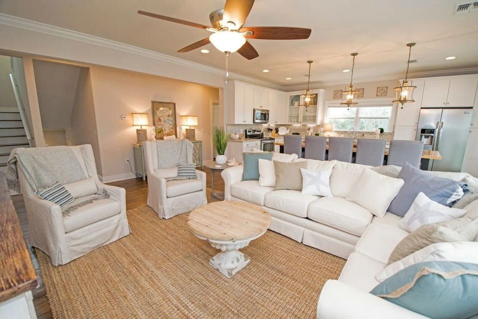 Spacious, open-concept living room with a comfortable sleeper sofa, Smart TV, and seamless flow into the dining area and kitchen.