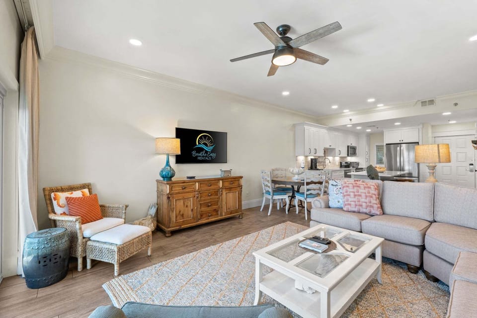 Inviting living room with smart TV, cozy seating, and adjacent dining space—perfect for relaxing after beach days.