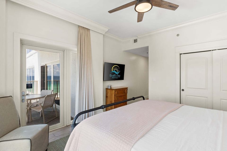 Spacious king bedroom with smart TV, tasteful coastal décor, and plenty of room to unwind after a beach day.