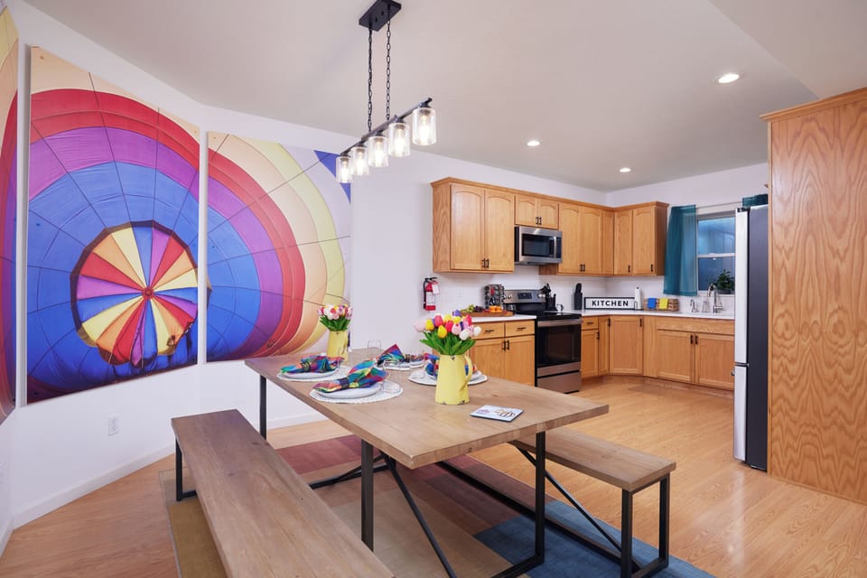 Bright dining area with full kitchen and vibrant statement wall art