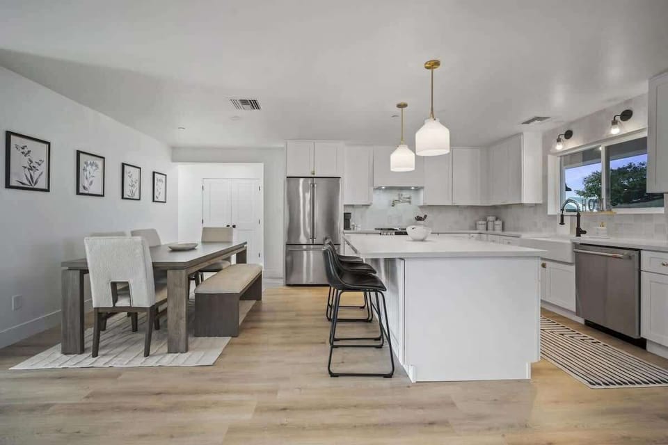 Bright, modern kitchen with a spacious island, sleek white cabinetry and stainless steel appliances.