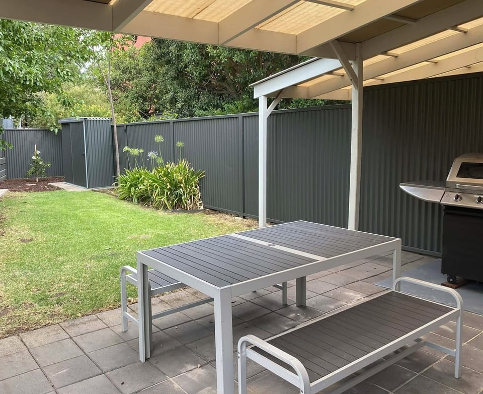 Fully enclosed backyard with BBQ and outdoor dining