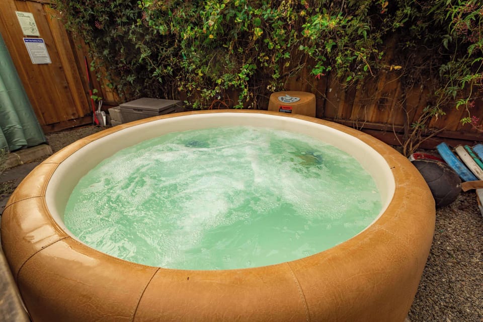 Relax and recharge in the bubbling hot tub, surrounded by greenery and natural wood accents