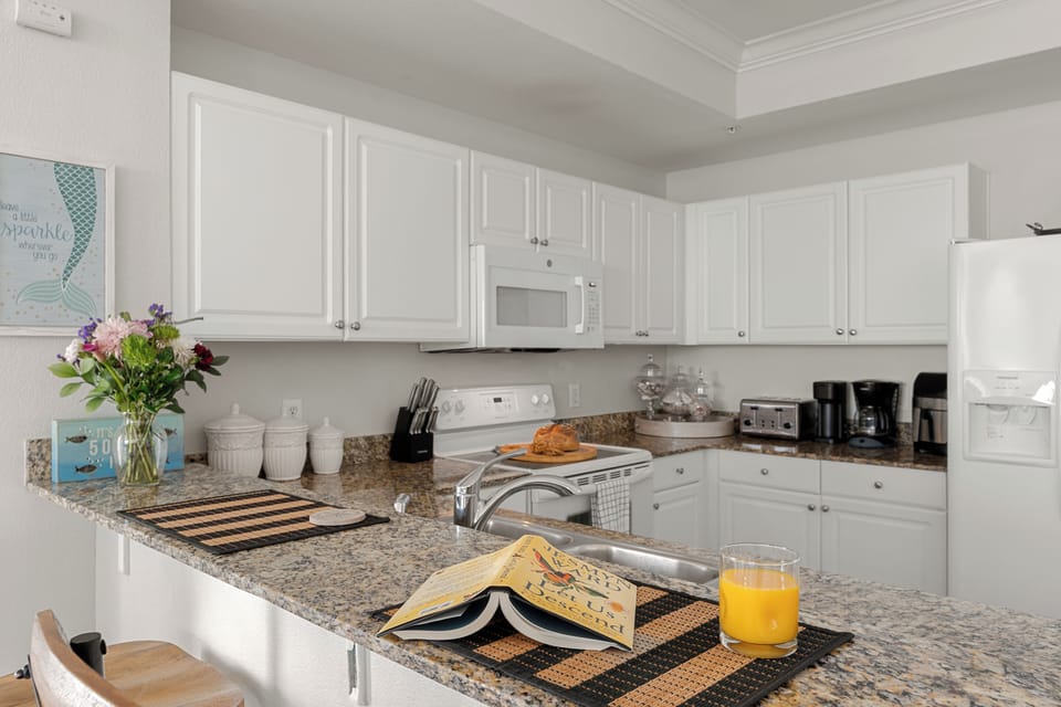 Bright, coastal-inspired kitchen with granite counters, full-size appliances, and all the essentials for preparing everything from quick breakfasts to family dinners.