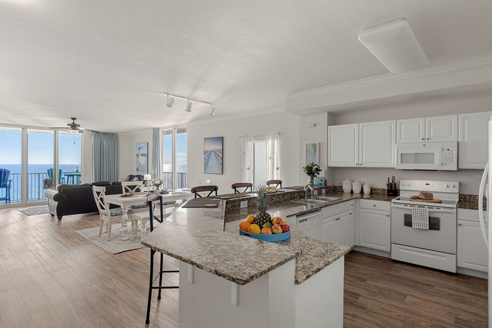 Granite breakfast bar with three stools overlooking the fully equipped kitchen—ideal for morning coffee, casual meals, or evening drinks.