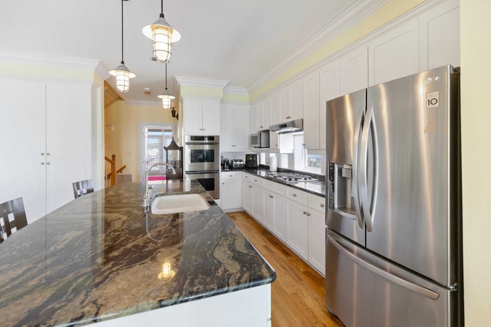 Your gourmet kitchen awaits with gleaming granite counters, stainless steel appliances, and elegant pendant lighting for memorable meals.