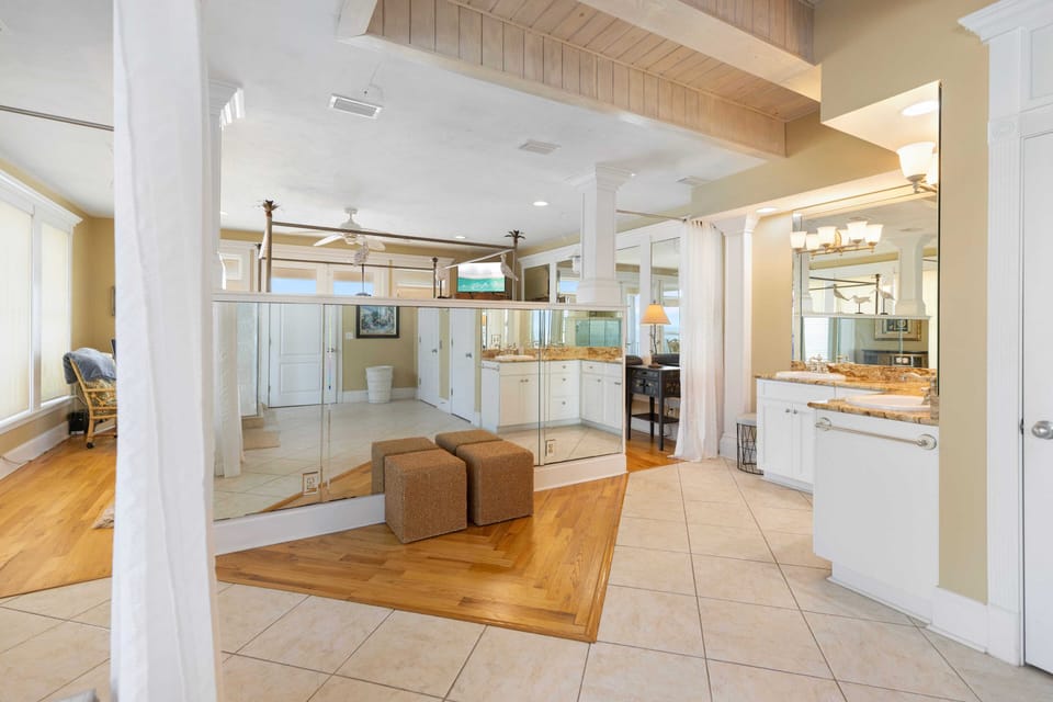 Step into your luxurious master suite featuring a dramatic glass-enclosed bedroom and spa-like ensuite with granite countertops and elegant finishes.