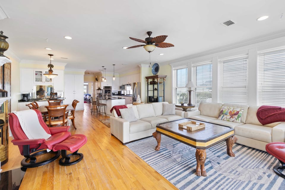 Relax in your spacious open-concept living area with plush seating, gleaming hardwood floors, and abundant natural light streaming through oversized windows.