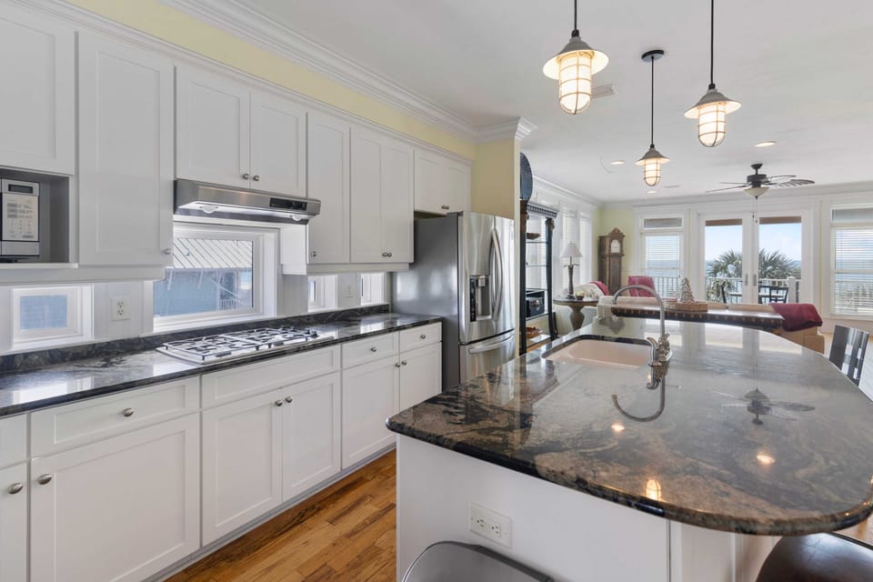 Your spacious kitchen features granite countertops, stainless appliances, and charming nautical pendant lights perfect for cooking memorable meals.