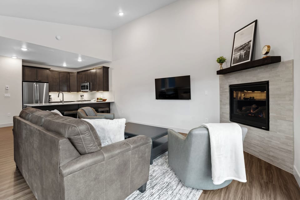 Unwind in your sophisticated living space where modern comfort meets elegant design, complete with cozy fireplace and open kitchen.