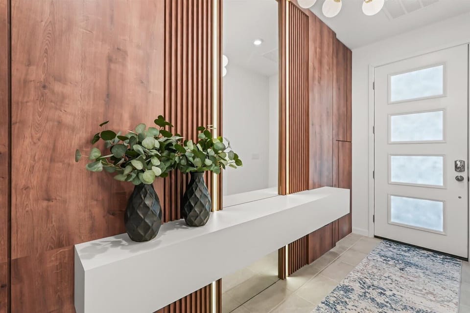 modern entryway with wood paneling, a large mirror, and decorative vases