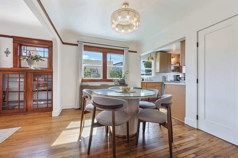 Relax in a bright Craftsman living room featuring original wood built-ins, a cozy leather sofa, and a large Smart TV. The perfect blend of historic charm and modern comfort.