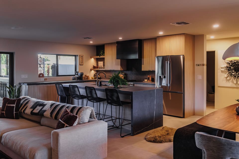 Modern kitchen with island seating flows into a comfortable living area — great for cooking and connecting.