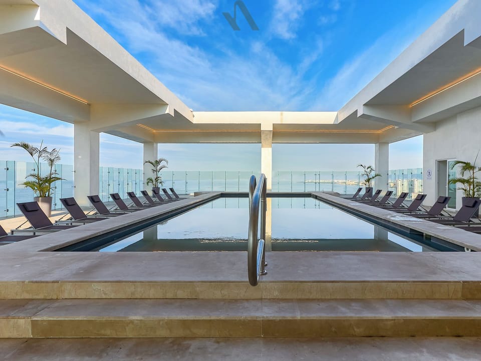 Enjoy a serene lap pool designed for swimming and relaxation, featuring modern loungers and floor-to-ceiling views from above.
